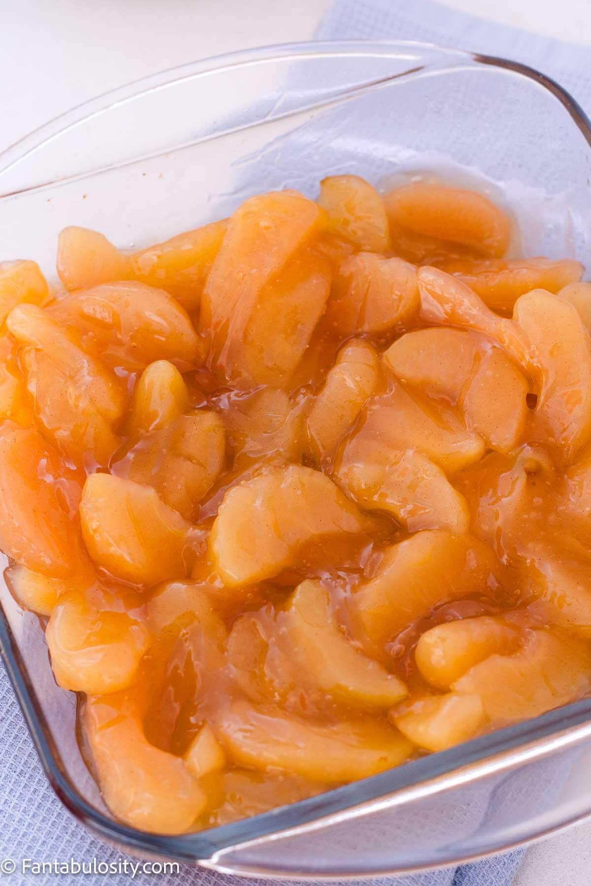 Canned apple pie filling spread in an eight-inch square glass baking dish.