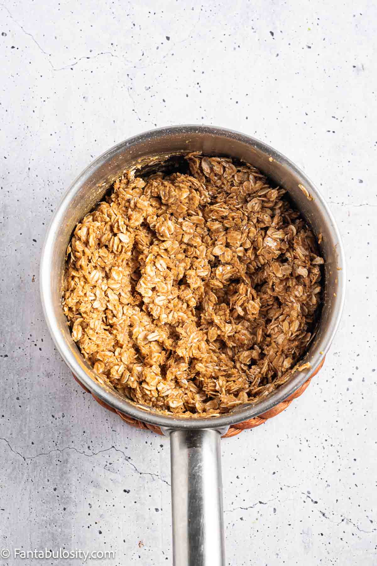 Old-fashioned oats mixed with peanut butter and honey in a saucepan.