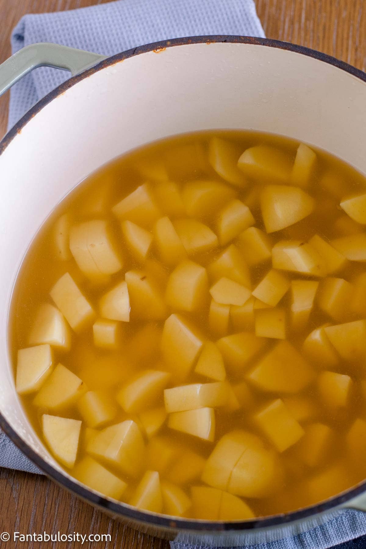 Yukon Gold potato chunks in chicken broth before cooking.