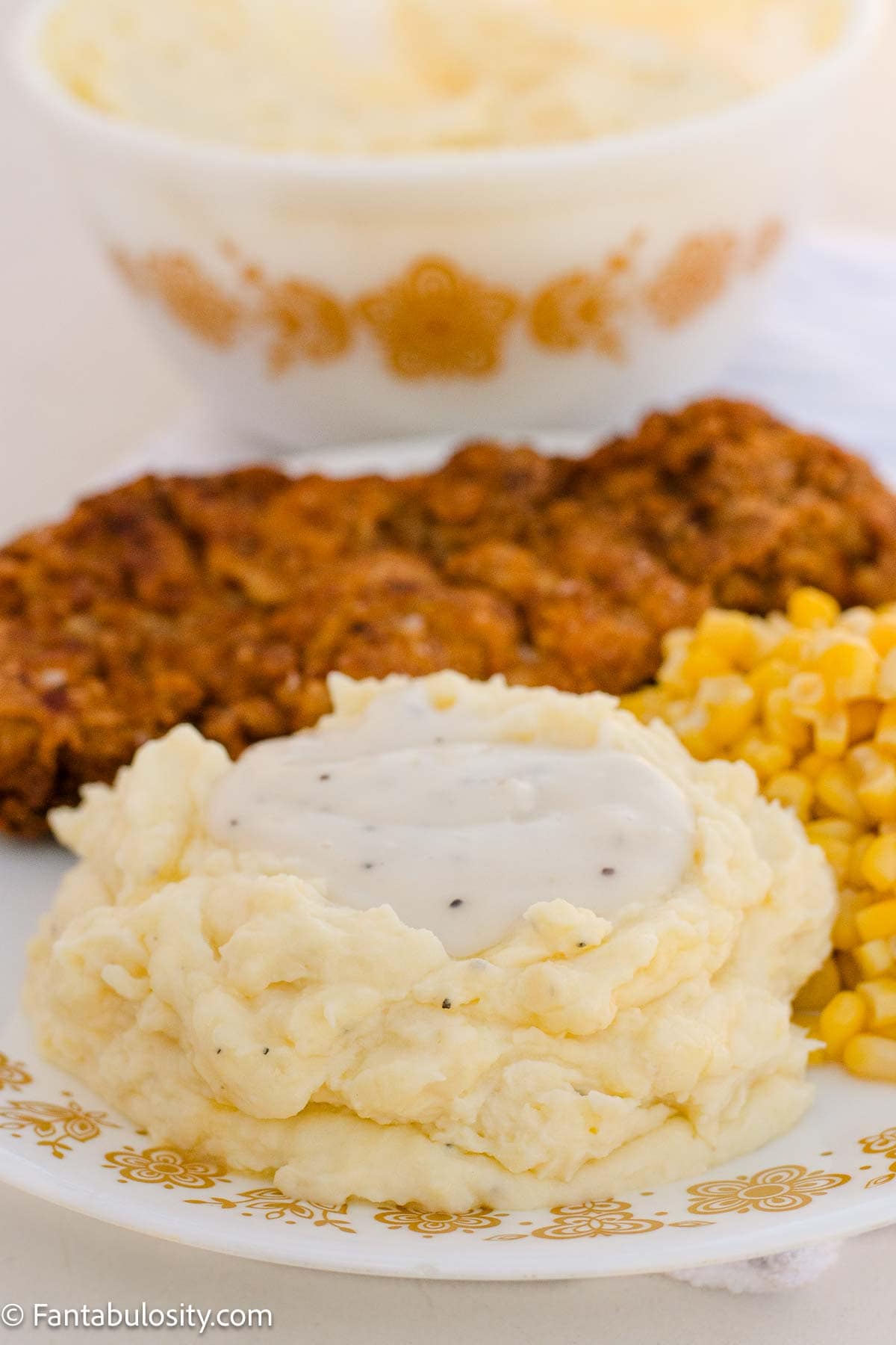 Sour cream mashed potatoes topped with white gravy, served with country fried steak and corn.