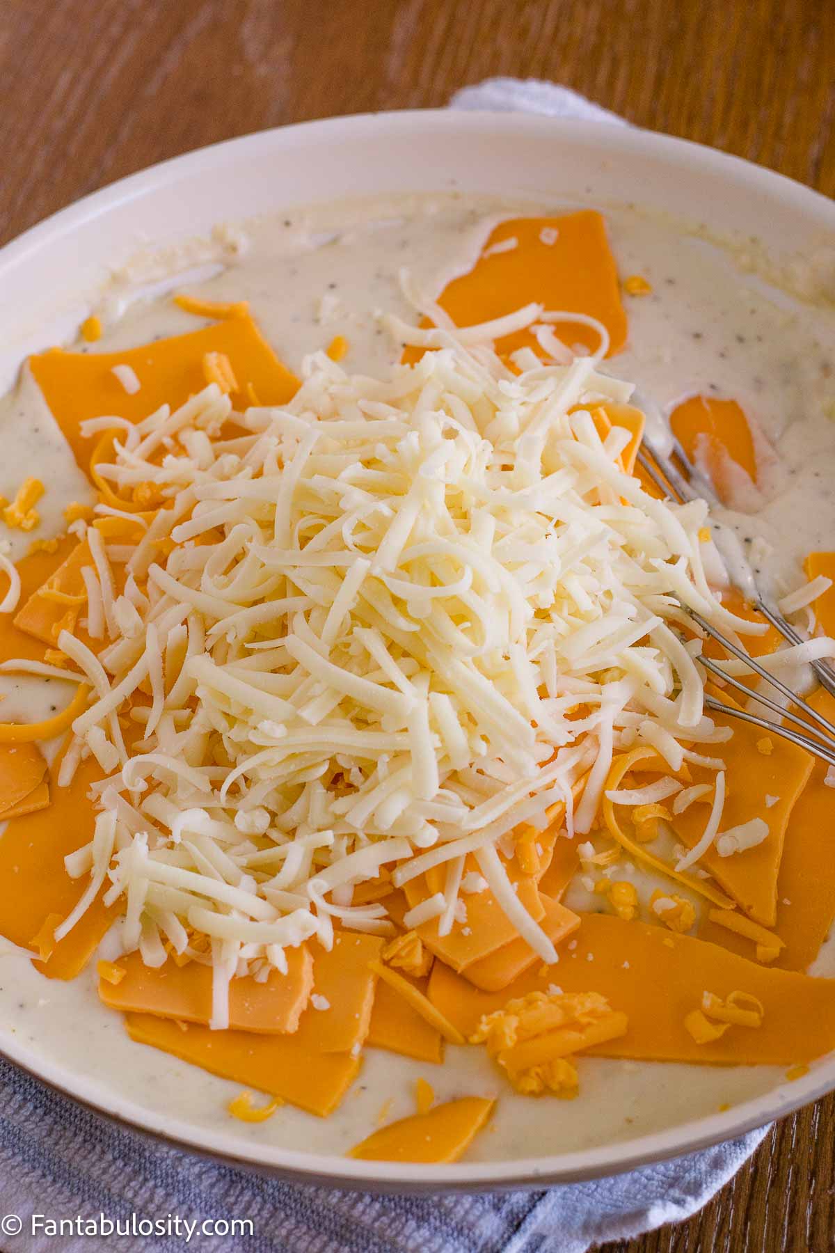 American cheese and shredded cheeses added to the warm milk sauce.