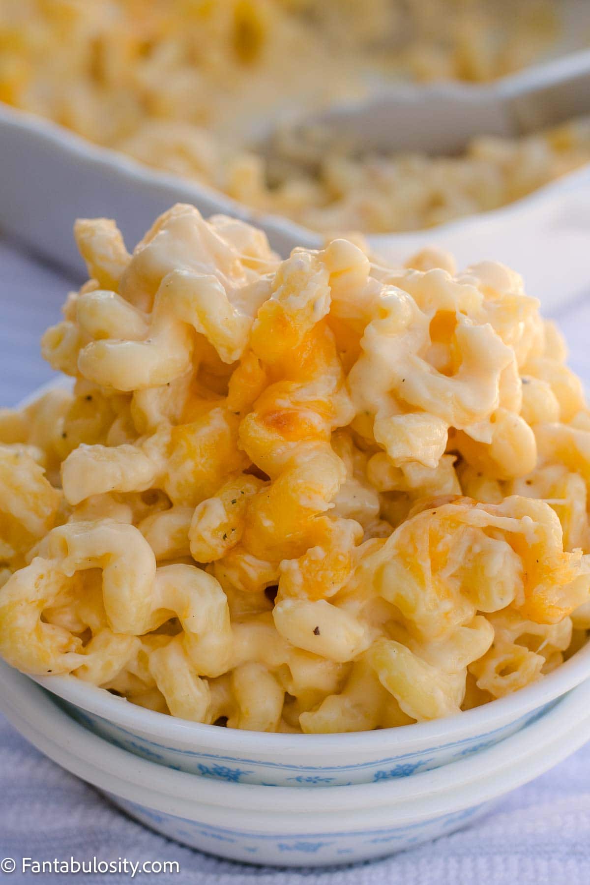Creamy cavatappi mac and cheese served in a blue-and-white bowl.