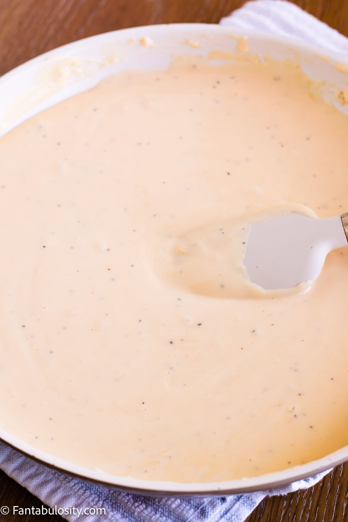 Smooth cheese sauce coating a spoon before adding the pasta.