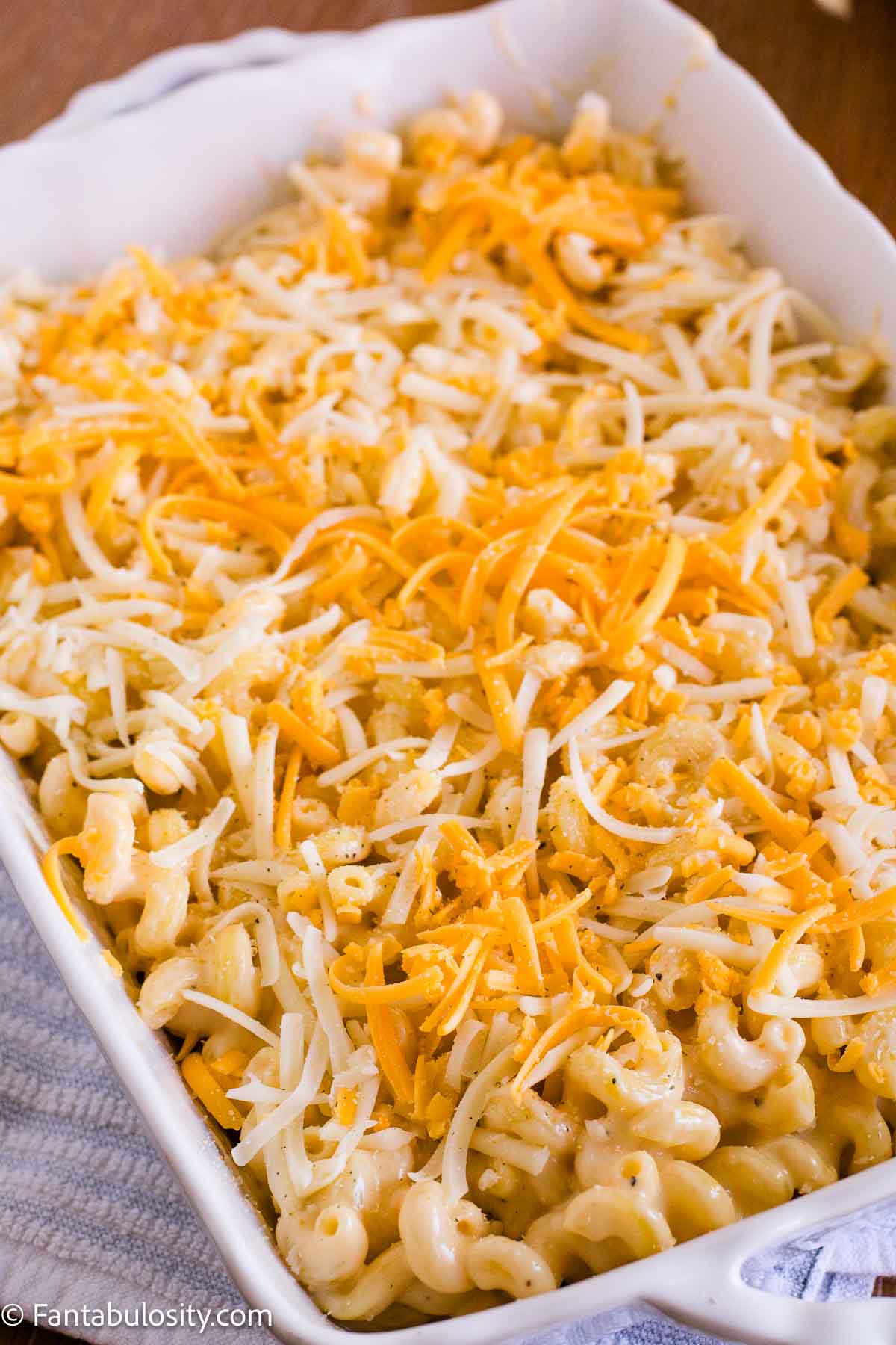 Mac and cheese topped with shredded mozzarella and cheddar before baking.
